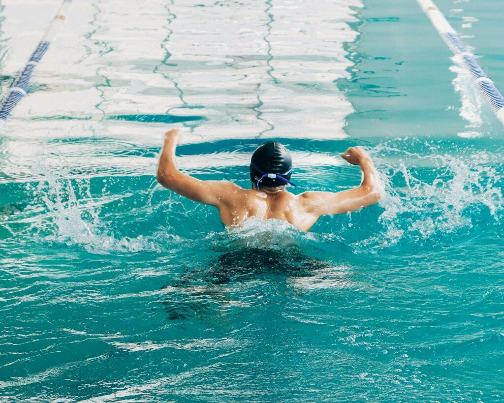 Professional swimmer in action during a practice session in an indoor pool, perfecting butterfly stroke.